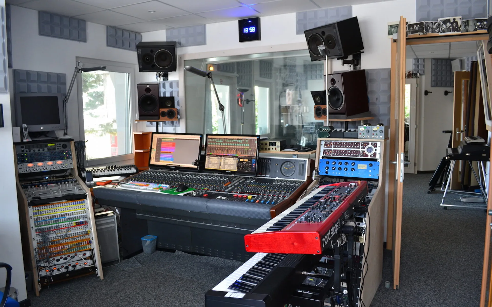 Vue de la régie du studio avec console et claviers